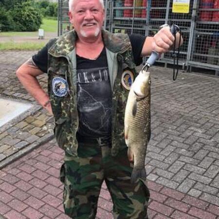 Mann hält gefangenen Fisch hoch